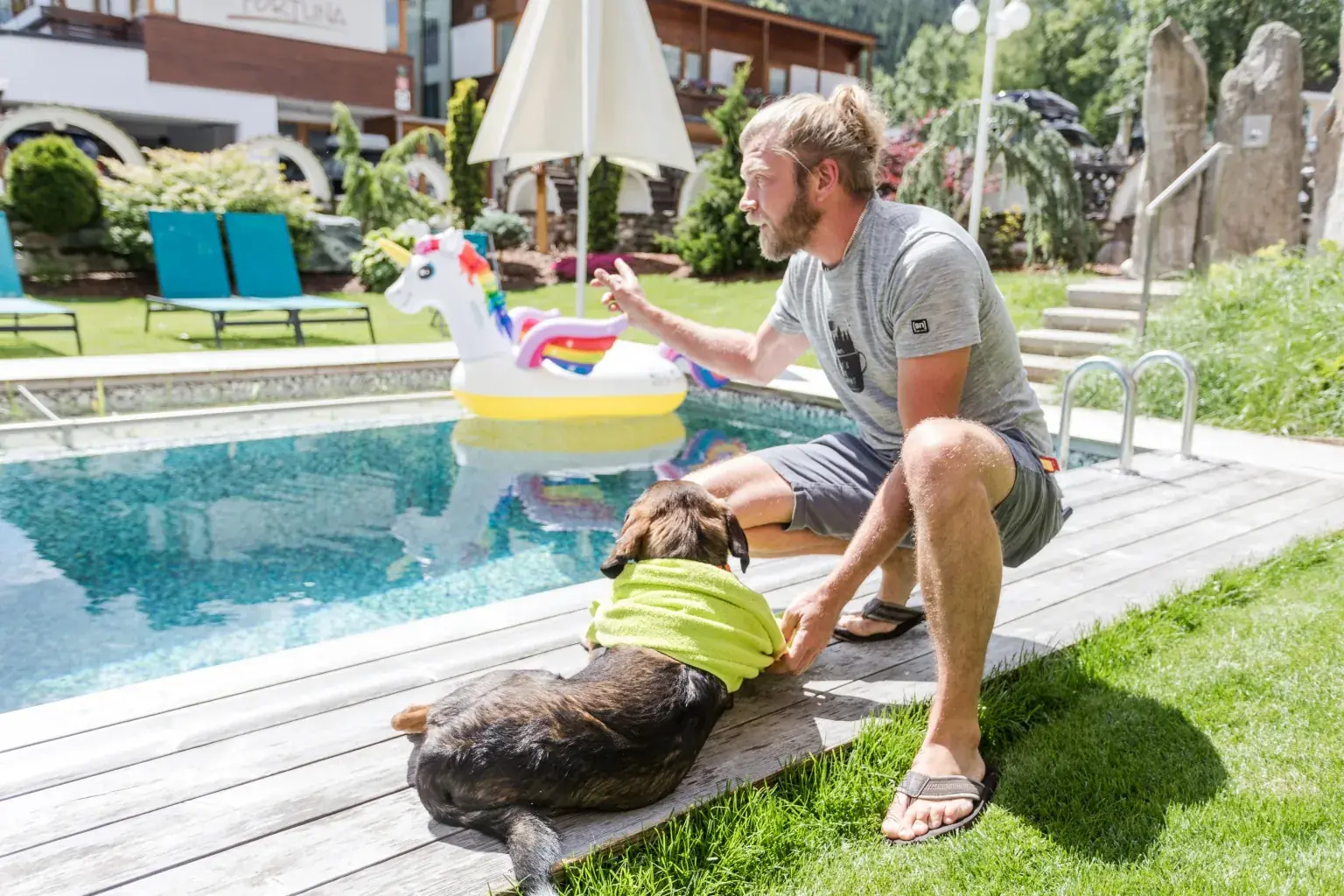 Mann mit Hund am Pool